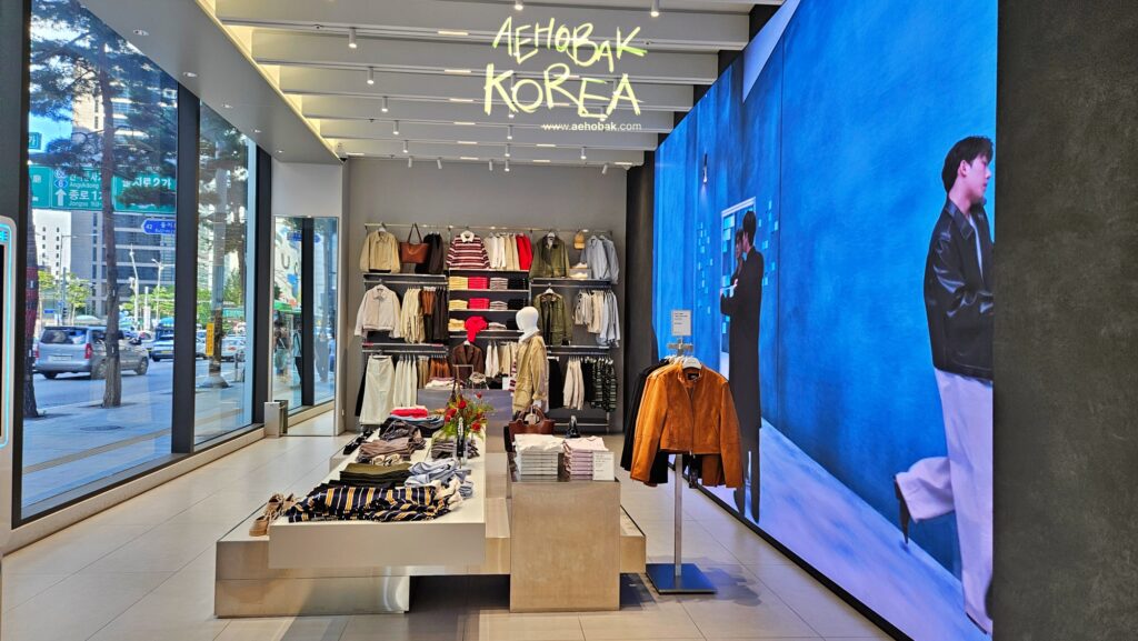 First floor display with folded clothes and a large video wall at Musinsa Standard Myeongdong.