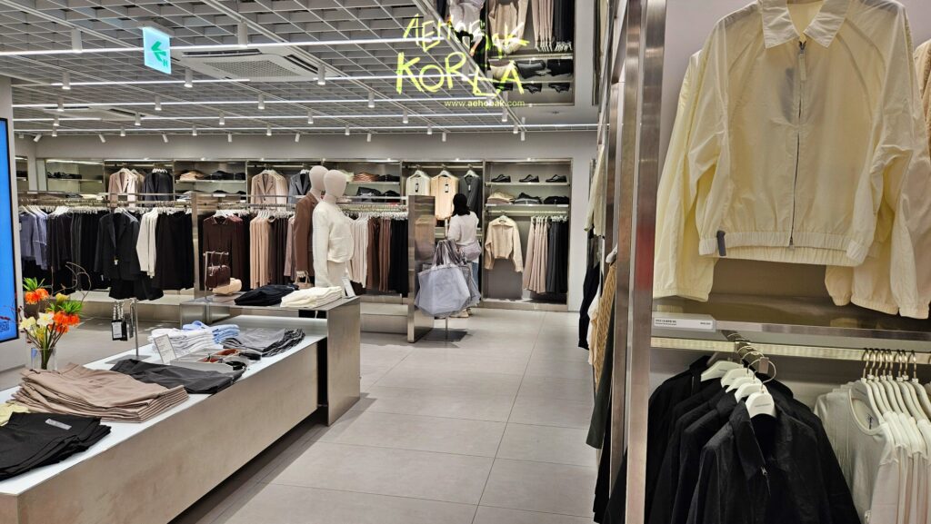 Women’s clothing section at Musinsa Standard Myeongdong with racks of shirts, jackets, and knits.