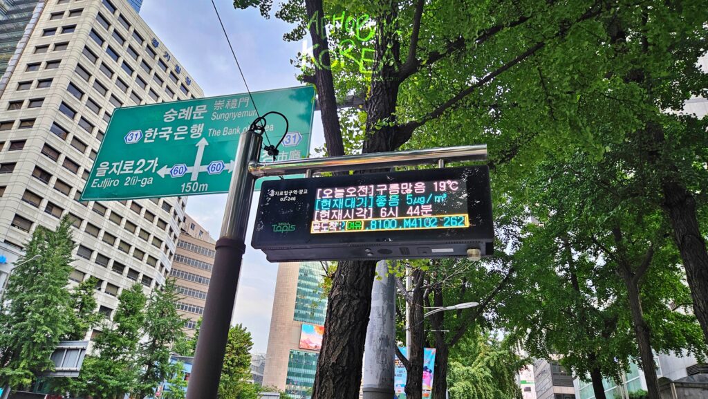 Electronic bus stop sign in Seoul showing arrival times, weather, and air quality